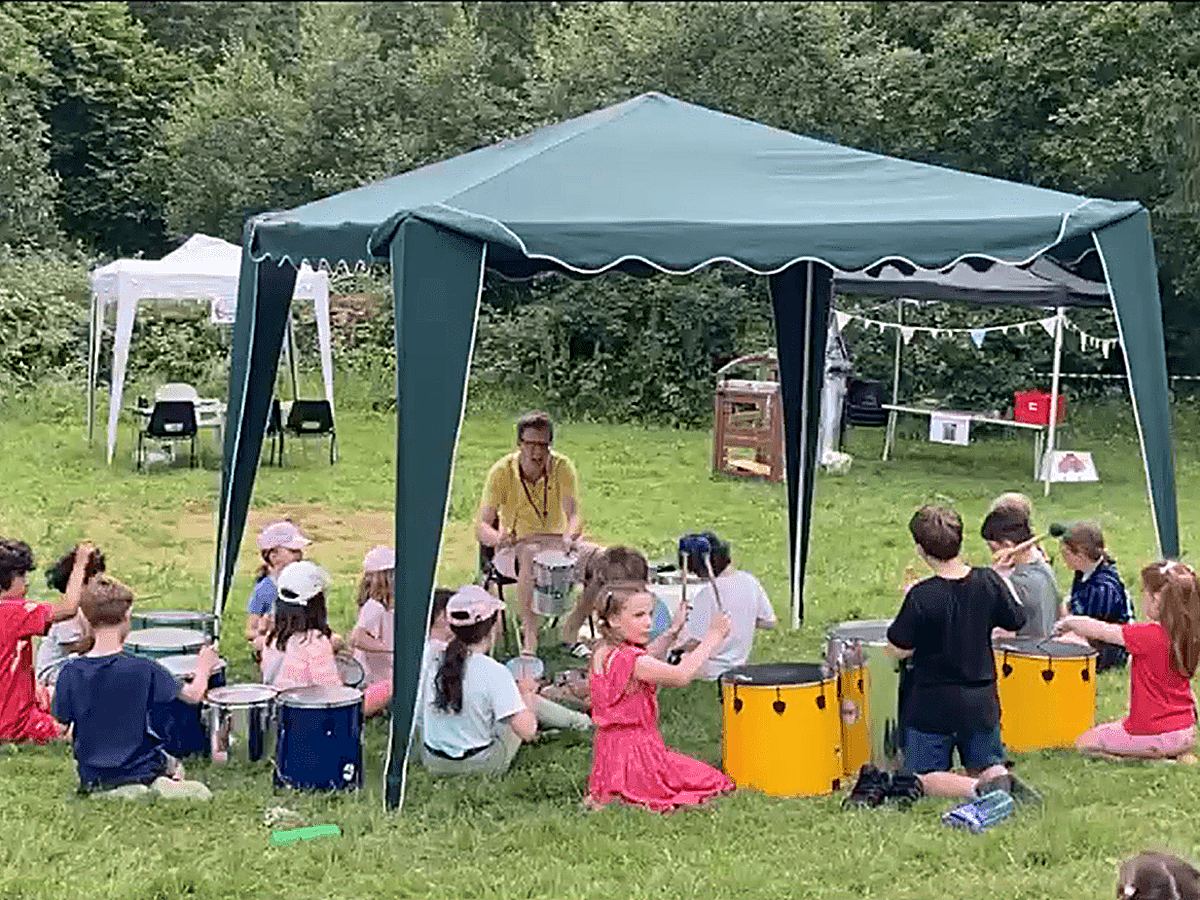 Children drumming at an outdoor Young Life session